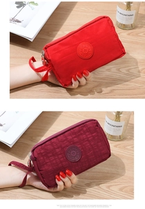 Dettaglio delle pochette in tessuto rosso con tripla cerniera e logo sportivo