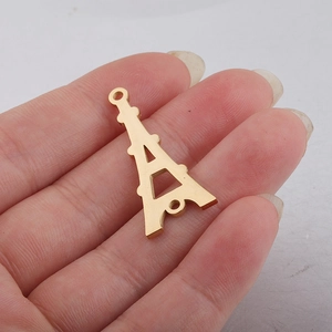 Nahaufnahme des goldenen Eiffelturm-Anhängers aus Edelstahl in der Hand gehalten