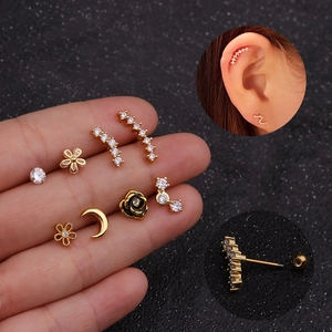 Close-up of gold stainless steel zircon studs and black rose helix earrings with screw backs