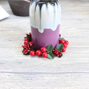 Ceramic purple and white glazed candle holder with red berry and green leaf wreath