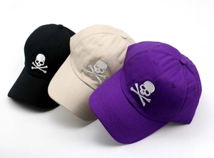 Detailed embroidery of skull and crossbones on cotton baseball caps in black and beige