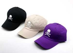 Detailed embroidery of skull and crossbones on black, beige, and purple baseball caps