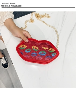 Detail of red glitter lip-shaped crossbody bag with rainbow prints and golden chain