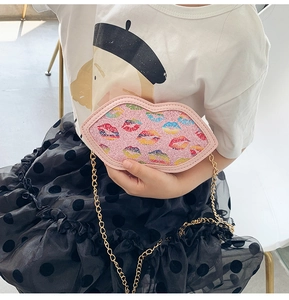 Detail of pink glitter lip-shaped kids bag with colorful lip patterns and gold chain