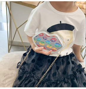 Detail of silver glitter kids crossbody bag with colorful embroidered lips and gold chain