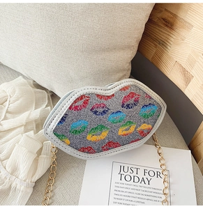 Close-up of a glittering silver lip-shaped crossbody bag with colorful patterns and gold chain