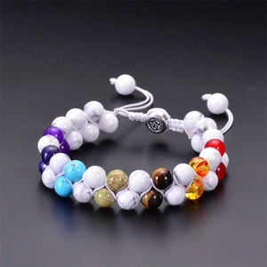 Close-up of double-layer turquoise beaded bracelet with Om charm on black background