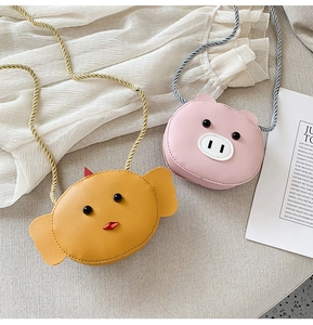 Detail view of mini animal coin purses in yellow chick and pink pig styles with woven straps