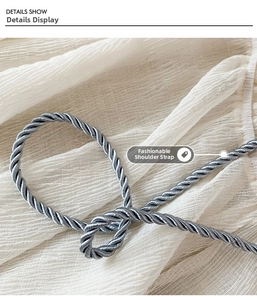 Detail show of blue twisted rope shoulder strap on soft white pleated fabric bag