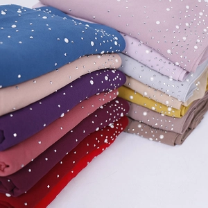 Detail of colorful chiffon headscarves with hand-sewn white pearls and shiny rhinestones