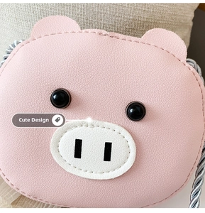 Close-up of pink pig cartoon shoulder bag in lychee pattern faux leather with woven strap