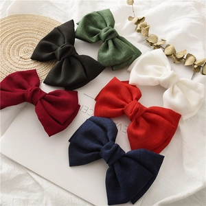 Detail of large textured fabric bow hair clips in six assorted classic colors