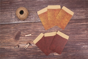 Flat lay of vintage kraft paper envelopes in tan and dark brown on a rustic wooden background