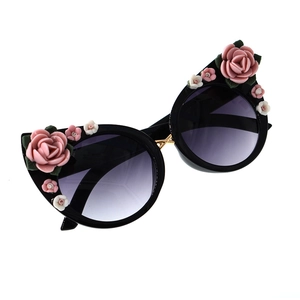 Detail of black round sunglasses featuring resin flower decor and purple gradient lenses