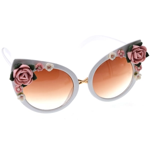 Detail of cat eye sunglasses featuring resin rose floral accents and gradient lenses