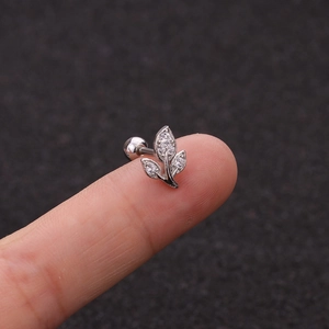 Detail view of leaf shaped zirconia stud earring with screw ball back held on a fingertip