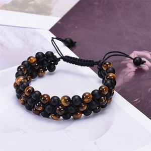 Detail of woven triple layer bracelet featuring brown tiger eye and matte black beads