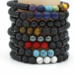Detail of men's braided leather bracelet with lava stone beads and magnetic metal clasp