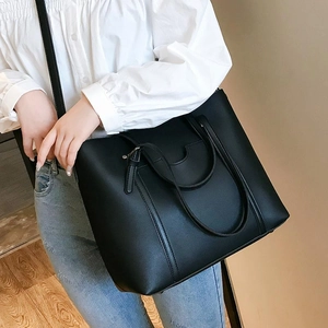 Model wearing a large black PU leather tote bag showing size and practical capacity