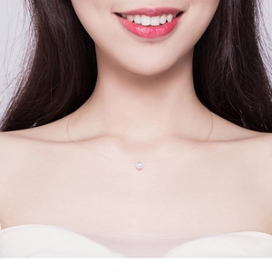 Close-up of minimalist invisible fishing line necklace with a sparkling zircon pendant