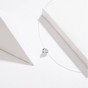 Close-up of a clear round zircon pendant on invisible nylon string with 925 silver clasp