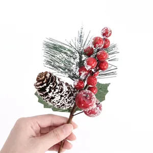 Christmas pine branch with red berries and pinecones featuring realistic snow details