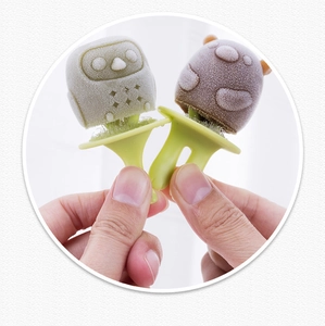 Macro view of owl-shaped frozen popsicles in grey and brown with frosted texture