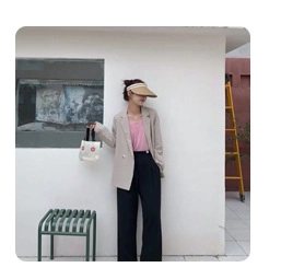 Outdoor shot of stylish beige leisure blazer paired with chic black high waist trousers