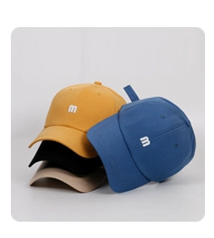 Detail view showing four solid color cotton baseball caps with embroidered M letters