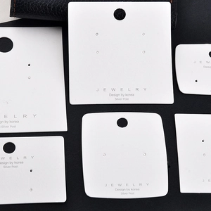 Close-up of premium white textured jewelry display cards for earrings and necklaces
