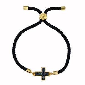 Dettaglio del bracciale nero intrecciato regolabile con ciondolo a croce dorata e blu