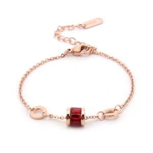 Detail of rose gold stainless steel bracelet with red bead and lobster clasp closure