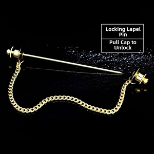Detail of gold metal collar pin with chain and dual locking caps on black background