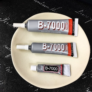 Three sizes of B-7000 clear jewelry glue tubes in 25ml, 15ml, and 3ml on a round tray