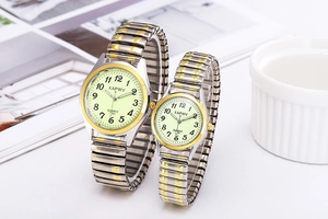 Detailed view of silver and gold luminous quartz watches with elastic metal bands