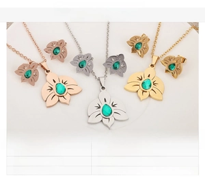 Detailed view of hollow floral jewelry set with green zircon in gold and silver steel