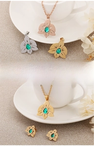 Detail of flower necklace and earrings set with green teardrop zircon in three colors
