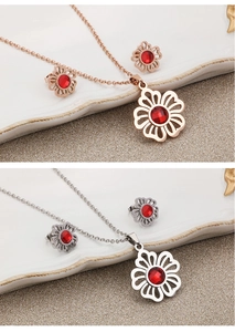 Detail of floral jewelry set with red gemstones in rose gold and silver finishes