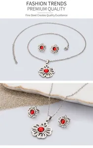 Detail of floral steel jewelry set with red zircon stones on a gold glitter background