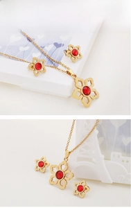 Detail of flower-shaped fine steel jewelry set with round red gemstone inlay