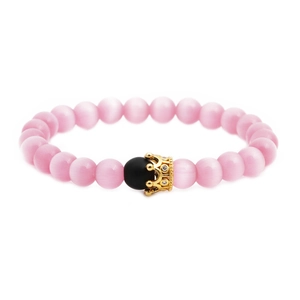 Pink cat eye stone crown bracelet with gold charm and black bead on white background