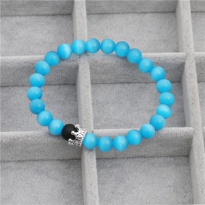 Detailed shot of blue cat eye stone beads and silver micro-set CZ crown on men's bracelet