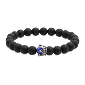 Close-up of matte black beads and blue cat eye stones with silver crown charm