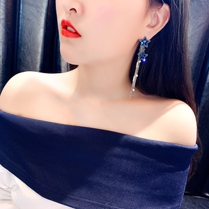 Orecchini a stella in argento con cristalli blu e lunghe nappe indossati dal modello