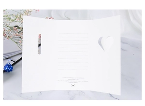 Detail of white tri-fold 3D butterfly heart card with printed quote on marble surface