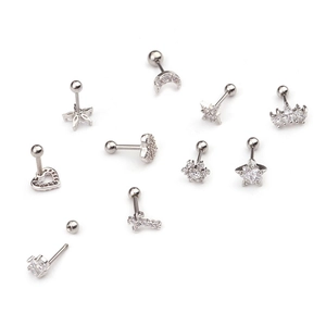 Macro detail of zircon earring set with moon, star, and crown shapes in silver finish