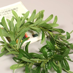Detailed close-up of olive leaf wreath showing realistic green foliage and texture on gray background