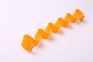 Detailed view of an orange spiral mesh heatless hair curler tool for wave styling