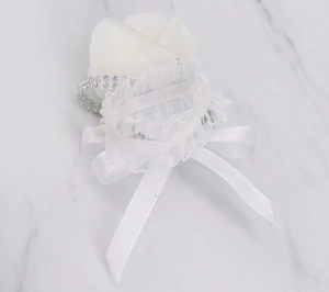 Detail of white fabric rose boutonniere with silk ribbon and sparkling rhinestone accents