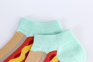 Detail of mint green ribbed cuff and colorful hot dog pattern on cotton blend socks
